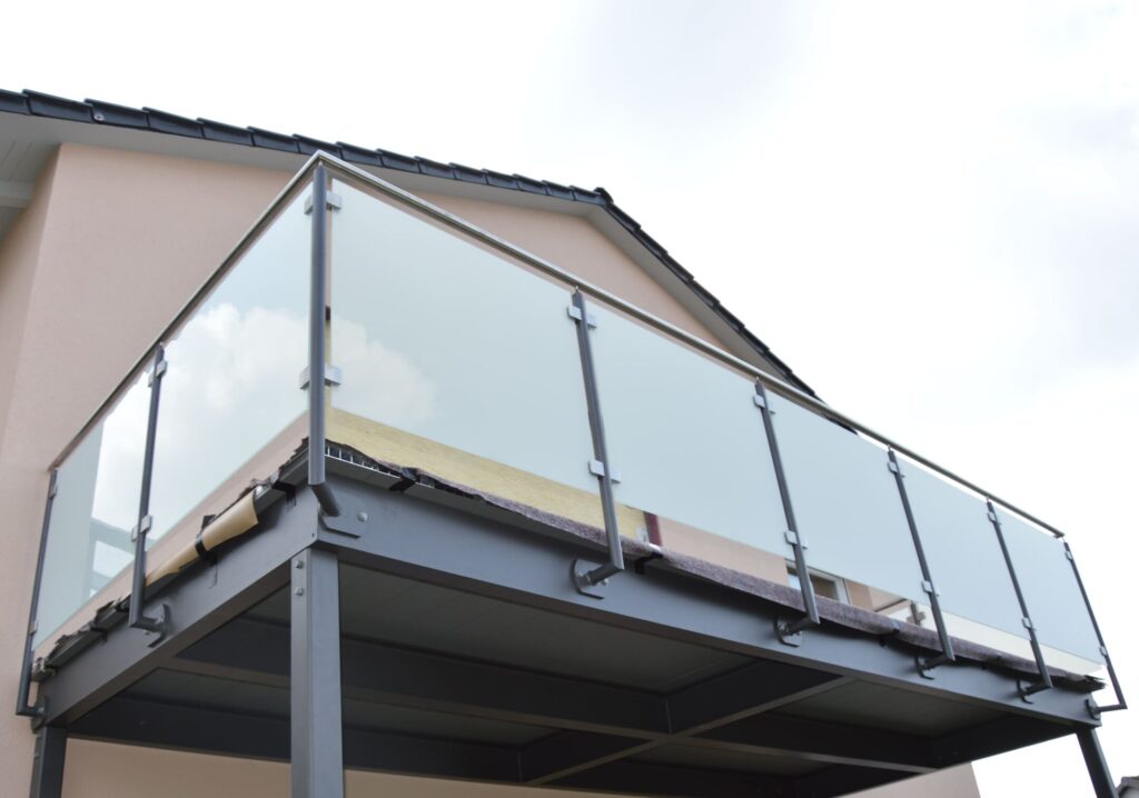 Balkonanlage pulverlackbeschichtet mit Edelstahlgeländer und mattweißen Scheiben