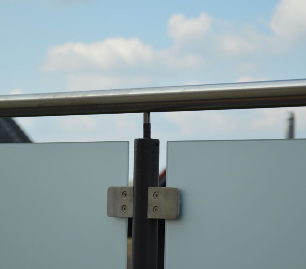 Detailansicht Pulverlackbeschichtetes Geländer mit Edelstahlhandlauf und mattweißen Scheiben